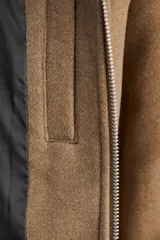 Campera bomber color marrón claro, de manga larga y cuello extendido. Cierre frontal con cremallera y bolsillos frontales. Confeccionada en mezcla de lana.