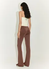 Pantalón marrón de tejido fluido con detalle drapeado en la cintura, diseño acampanado y estilo flare.