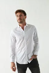 Camisa blanca de algodón con fit slim, manga larga y logo bordado. Colección Primavera Verano 2025.