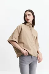 Camisa color beige de corte oversize y manga corta.