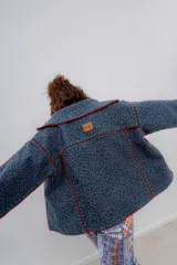 Chaqueta azul con detalles de crochet rojo y verde, de paño de lana, corte oversized.