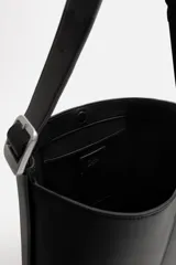 Bolso tipo shopper color negro, con compartimento principal con cierre mediante imán y bolsillo plano interior. Asa de hombro ajustable.
