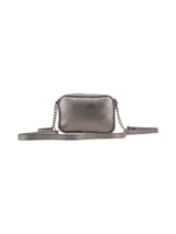 Bandolera rectangular color peltre, con textura granulada y logo metálico de la marca en el frente. Tiene correa larga de cuero sintético y cadena metálica.