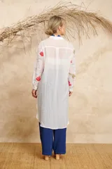 Camisa larga blanca con estampado de motivos marinos en tonos rojo, azul y verde.