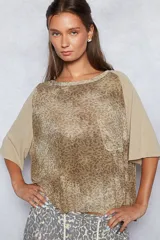 Remera manga corta color beige con estampado animal print y bolsillo delantero.