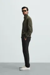 Pantalón chino color beige, corte skinny fit, confeccionado en tejido con mezcla de algodón y elasticidad. Cuenta con bolsillos frontales y traseros. Cierre frontal con cremallera y botón.