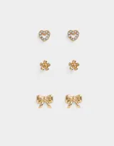 Set de tres pares de aros pasantes dorados: un par con forma de corazón con strass, un par con forma de flor y un par con forma de moño.
