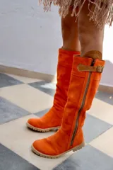Botas altas de gamuza color rojo con forro de cuero, cierre lateral y suela de goma.