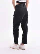 Pantalón de jean negro, corte mom fit, tiro alto y bolsillos delanteros y traseros.