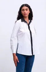 Camisa de manga larga con estampado abstracto de flores en tonos rojo, azul y verde sobre fondo negro. Se ata en la parte delantera.