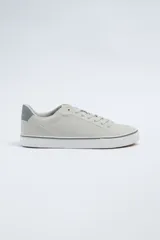 Zapatillas acordonadas de cuero sintético color gris claro, con suela blanca y detalles en gris oscuro en el talón y en la línea superior de la suela.