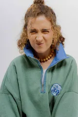 Buzo verde y azul con cierre metálico y bordados de flores.