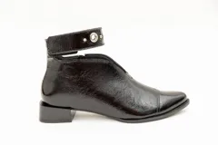 Botín de cuero color borgoña con taco bajo, corte en V en el empeine, pulsera con detalles metálicos y cierre lateral.