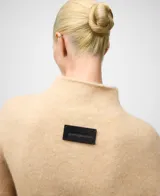 Cárdigan de punto color camel con cuello chimenea y cierre frontal de botones al tono. Posee manga larga con hombro caído y terminaciones en canalé en puños y bajo. Confeccionado en una mezcla de lana merino y alpaca.