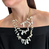 Collar de tres vueltas con cadena dorada y cuentas irregulares de nácar.