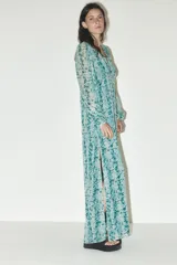 Vestido largo de escote en pico y manga larga, con estampado floral en tonos celeste y verde.