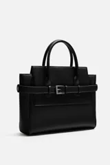 Bolso bandolera negro con detalle de cinturón, compartimento principal con cierre mediante doble imán, bolsillo interior con cierre mediante cremallera, dos asas de mano y un asa de hombro ajustable y extraíble.