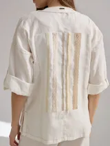 Camisa color coral de lino, corte holgado, escote redondo y mangas 3/4 ajustables con botón.