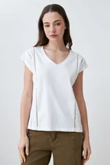 Remera color durazno con escote en V y detalle de vainillas en los laterales. De manga corta y corte recto.