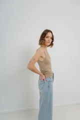 Musculosa amarilla de hilo con brillo sutil, de calce ajustado y breteles finos.