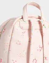 Mochila pequeña de cuerina color crema con estampado de flores pequeñas en tonos rosa, naranja y celeste. Tiene un bolsillo frontal con cierre, correas regulables, manija superior, cierre superior y bolsillos laterales.