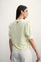 Remera de manga corta con cuello redondo y estampado de rayas horizontales blancas y negras. Mangas abullonadas con puño blanco.