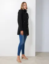 Gabardina impermeable de mujer, color marrón topo, con capucha desmontable y forro interno de abrigo desmontable. Presenta abertura central con cierre oculto y botones a presión, y bolsillos delanteros.