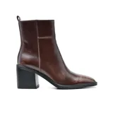 Botas de cuero negro con caña media, punta cuadrada y taco geométrico. Presentan un tirador trasero y elástico lateral para facilitar el calce.