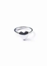 Anillo plateado de acero quirúrgico hipoalergénico con dije de corazón.
