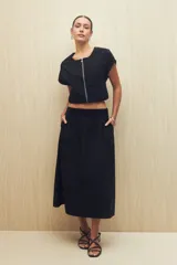 Falda midi negra de mezcla de algodón, nylon y elastano, con cintura elástica y bolsillos laterales.