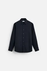 Camisa azul marino de corte regular, confeccionada en tejido de fácil cuidado. Cuenta con cuello italiano, manga larga con puños abotonados y cierre frontal con botonadura.