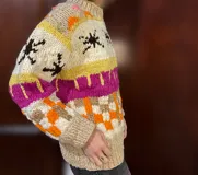 Sweater de lana merino con cuello redondo y diseño con motivos geométricos en tonos azul, marrón, naranja, verde y beige.