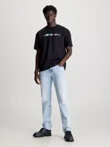 Remera negra de algodón con cuello redondo y mangas cortas. Estampado frontal con el logo de Calvin Klein Jeans en letras blancas con detalles fotográficos en colores celeste, rosa y gris.