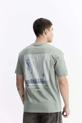 Remera de manga corta color verde menta, con escote redondo y fit regular. Presenta un estampado en la espalda con la frase "NO RULES! BREAK THE RULES" y un diseño abstracto en tonos azules y blancos.