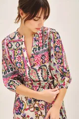 Vestido corto con estampado floral multicolor, cuello redondo, mangas 3/4 y lazo para ajustar en la cintura.