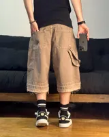 Bermuda de corte baggy color marrón con efecto gastado (lavado vintage), doble carpintero y detalle artesanal visible en el bajo. Incluye un cordón extra confeccionado en la misma tela.