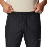 Pantalón deportivo negro de corte ajustado, con cintura elástica ajustable, bolsillos laterales con cierre y puños elásticos.