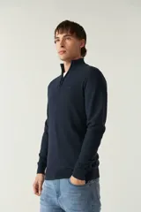 Sweater gris de punto con medio cierre, cuello alto y logo bordado en el pecho.