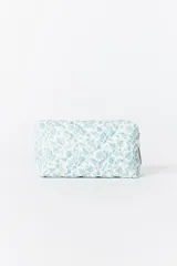 Cartuchera acolchada con cierre, estampada con flores pequeñas en tonos celestes y blancos.