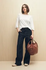 Pantalón de jean azul oscuro, de corte recto y tiro alto, con costuras a la vista.