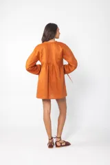 Vestido corto azul con escote con cordones, mangas largas abullonadas y corte evasé.