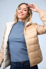 Campera puffer reversible color beige, marca Michael Kors. Un lado es liso y el otro estampado. Tiene cierre metálico central, bolsillos delanteros y bolsa autoportante.
