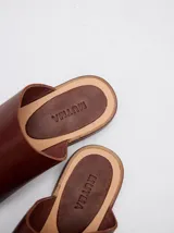 Sandalias de cuero color marrón con tira ancha sobre el empeine y abertura para el dedo gordo.