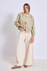 Cazadora color verde oliva con cuello redondo, cierre frontal con botones y mangas largas con puños elásticos.