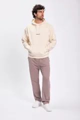 Pantalón deportivo color visón con cordón ajustable en la cintura y bolsillos laterales.