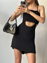 Mono corto negro con escote recto, tirantes finos y abertura en la cintura.