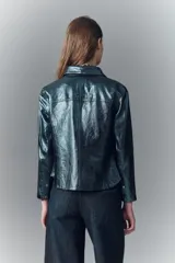 Camisa entallada de cuero ovino verde metalizado, con cuello camisero y botones a presión con logo.