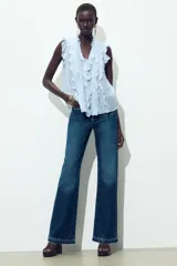 Blusa celeste sin mangas con escote en V y volantes.