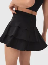 Falda corta deportiva negra con calza incorporada y tablas plisadas.