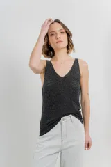 Musculosa tejida negra con sutil hilo brillante, escote en “V” delantero y trasero.